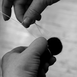 Traditional production of a brushes head. After shaping, the hairs are being tied together. 